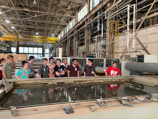 Students check out a pool for water cutting at the NASA machine shop