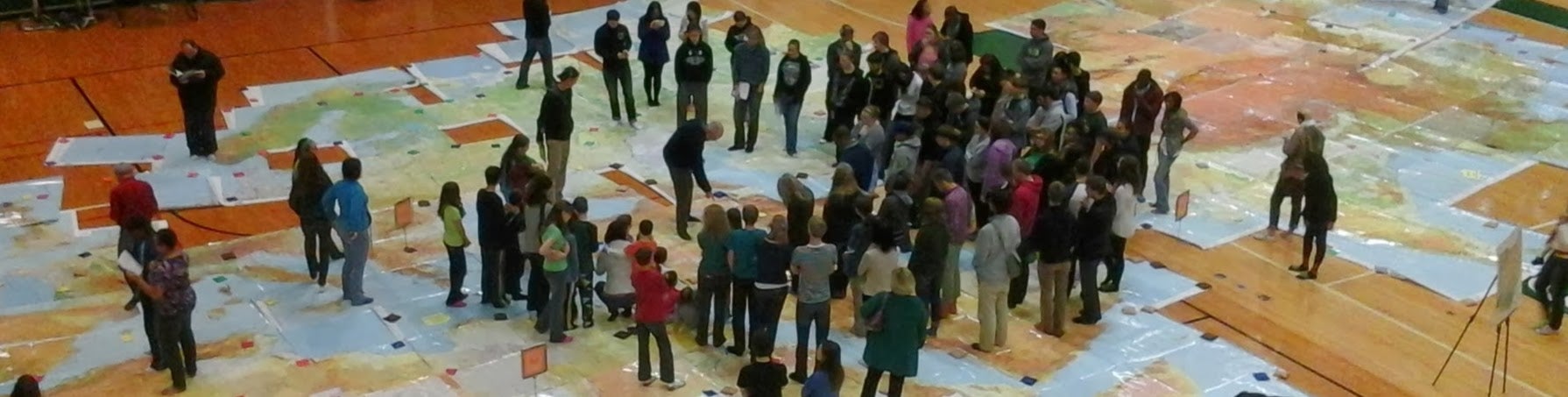Students standing on a map of the world