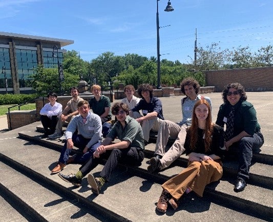 a group of students pictured sitting on steps