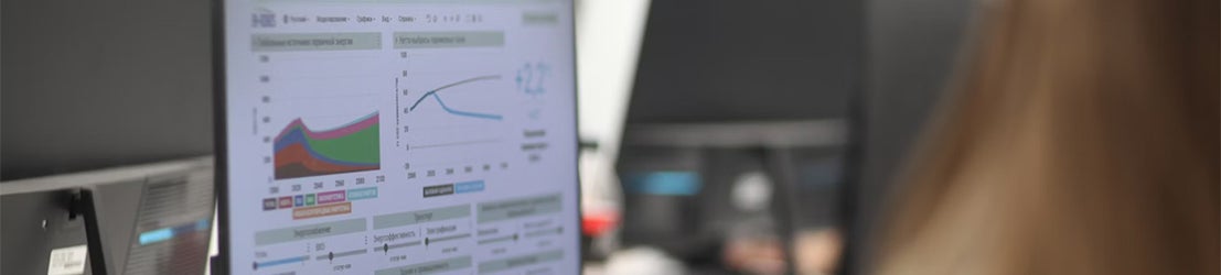 A female student working on data analytics and graphing on a computer monitor in a classroom.
