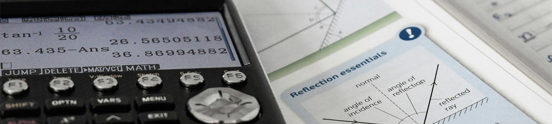 A close up of a calculator and a math textbook showing equations in a well-lit environment.