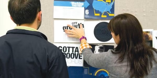 two people looking at a tackboard of pamphlets