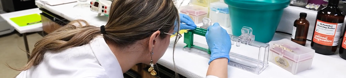 A student working on research equipment in a lab.