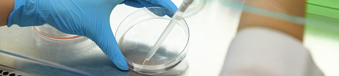 A student handling research equipment in a lab.