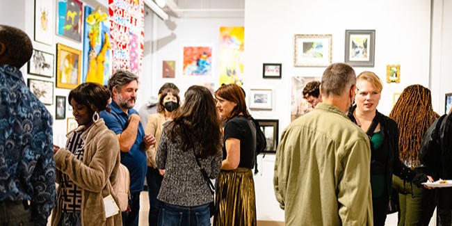 People standing talking in an art gallery