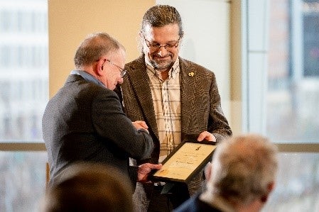 Dr. Streletzky gives Dr. Walker the award plaque.