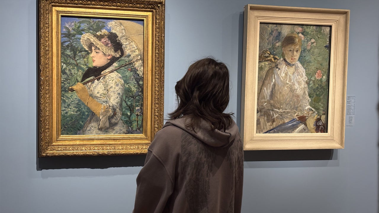 A student looking at modernist portraits in a museum.