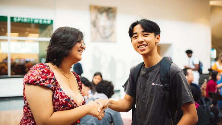 Two Asian students shaking hands