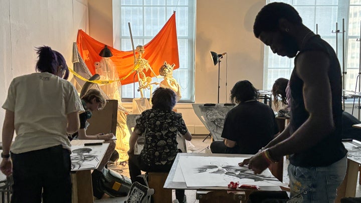 Student artists draw skeletons in a life drawing class.