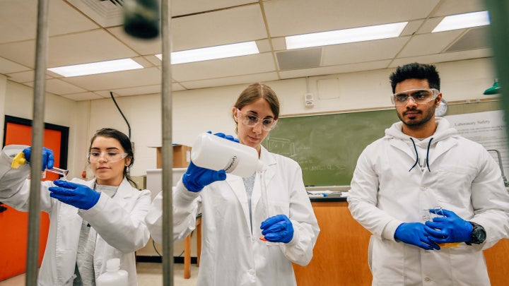 Three students working on research in a lab.