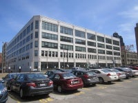 A building with across from a parking lot. Shows the Middough building or the arts campus.