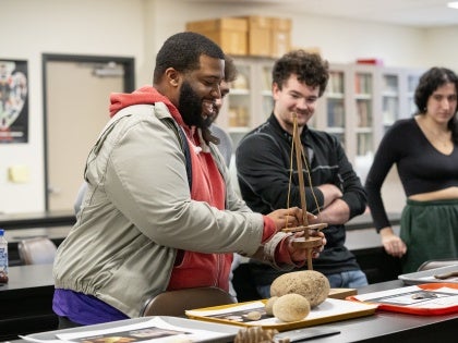 Anthropology students in class interacting with artifacts