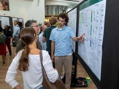 Two professors and a student discussing research poster in poster session event at CSU.