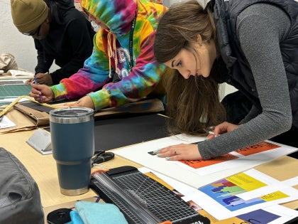 Three students working on design projects in a design classroom.