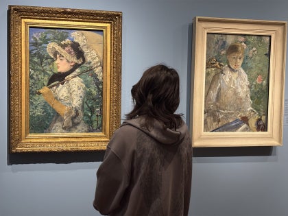 A student looking at modernist portraits in a museum.