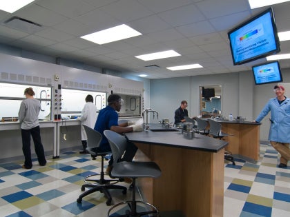 A group of students and a professor working in a research lab.