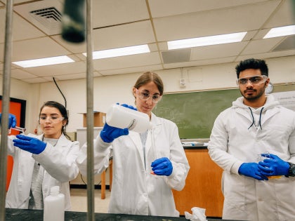 Three students working on research in a lab.