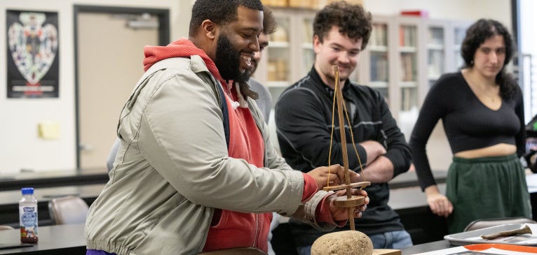 Anthropology students in class interacting with artifacts